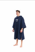 Person wearing a navy blue hooded poncho with a logo on a white background