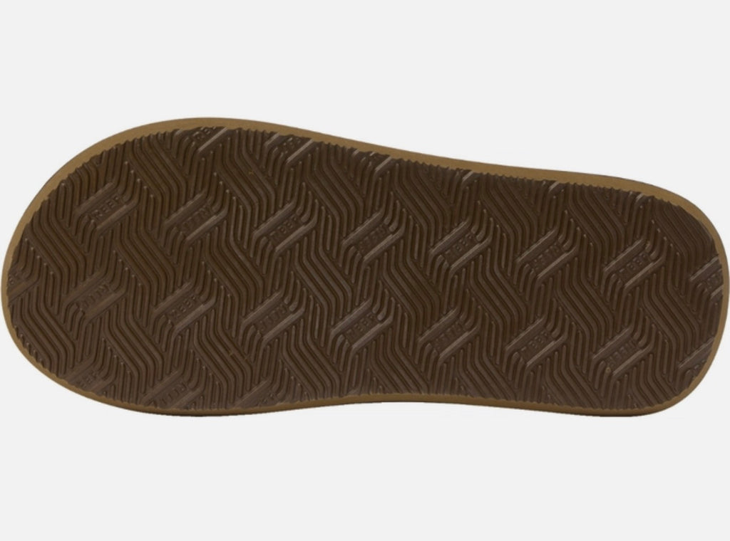 Close-up of a brown reef sandal sole with wavy tread pattern on a white background