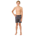 Young boy wearing patterned Ripcurl shorts on a white background