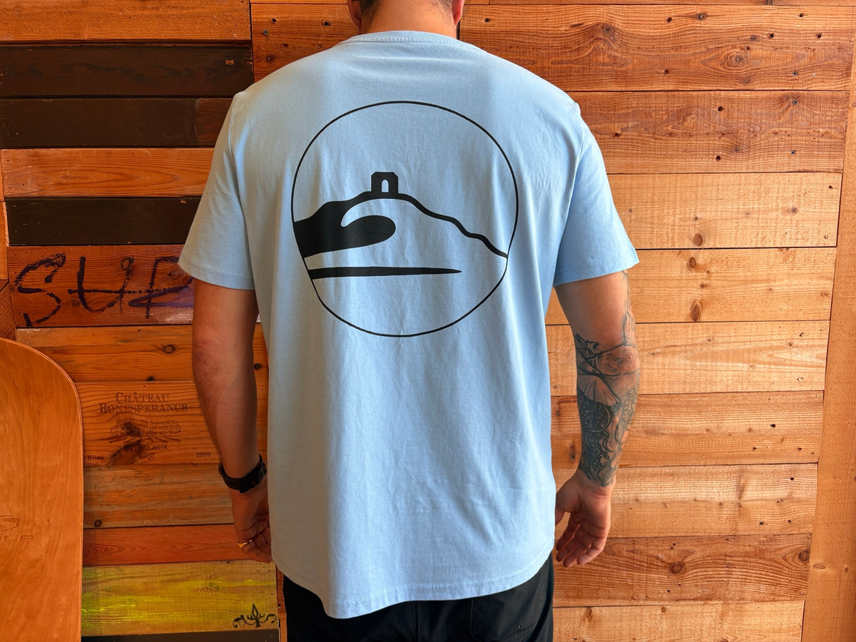 Adventure Bay Surf Shop round logo tee in blue back view worn by male model