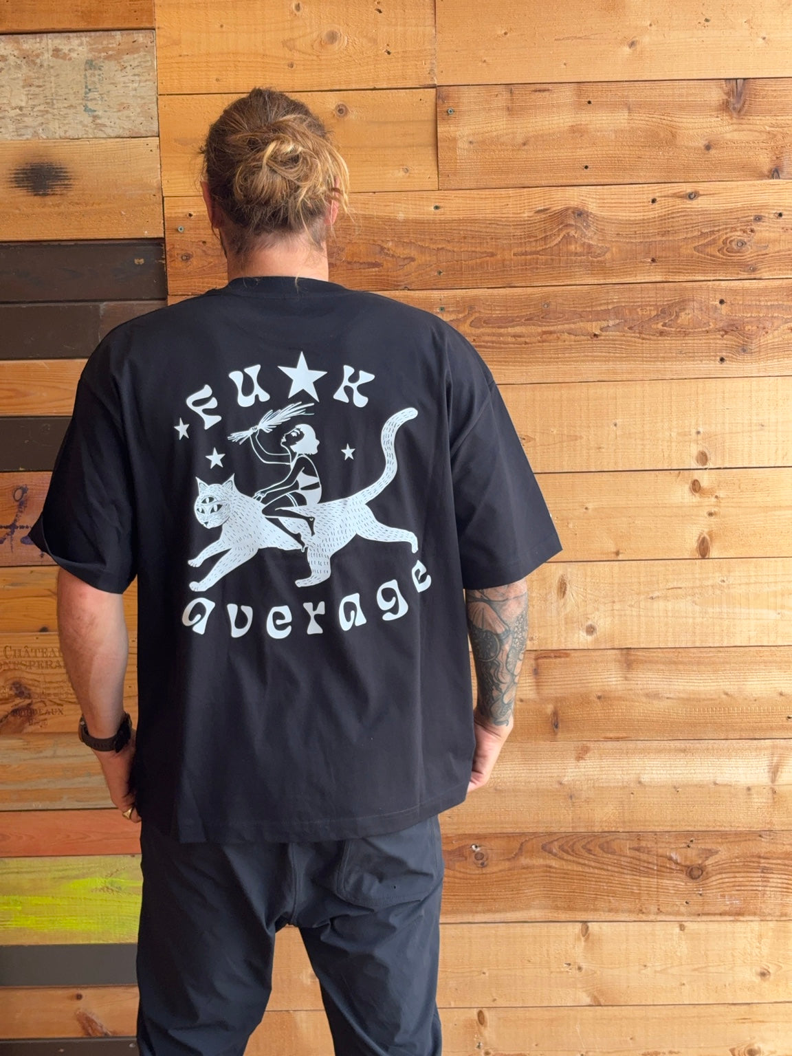 Starborn Fuck Average black unisex tee back view with woman riding cat graphic